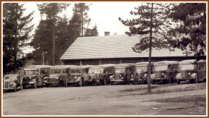 <pre>Onni Tuovisen autot ja 
lähes koko henkilö-
kunta 20.11.1949 neljä 
vuotta aikaisemmin 
valmistuneen talli-
rakennuksen edessä.</pre>